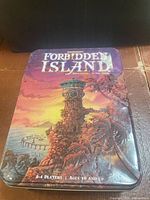 Closed Forbidden Island metal tin showing cover art