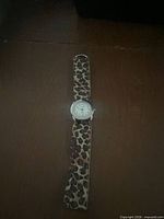 Full view of wristwatch with leopard fabric band