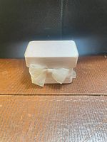Front view of ivory satin jewelry box with ribbon bow