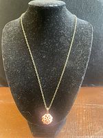 Full view of necklace on display bust showing chain length and pendant