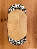 Top view of wooden bread tray showing metal pebble design end caps