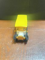 Front view showing yellow roof, white hood, black bumper, gold details