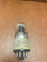 Front view of Zenith 6J5 tube standing upright showing logo, model number, and pin base