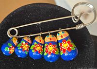 front view showing brooch and painted charms