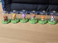 All six Digimon figures in domes on table