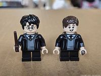 Front view of both minifigures showing uniforms, faces, and wand accessories