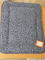 Front view of blue plush pet mat with tag visible