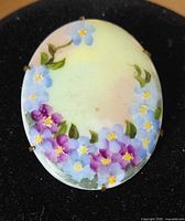 front view showing floral painting and pronged frame