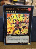 Front view of Number 61: Volcasaurus card showing artwork, Gold Rare foiling, set code ZTIN-EN002