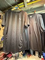 Both Under Armour t-shirts hanging for overall view