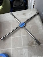 Full view of steel 4-way lug wrench on tabletop