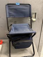 Front view of folded stool showing seat and attached cooler bag