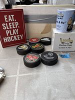 Overview showing sign, mug on boxes, six pucks