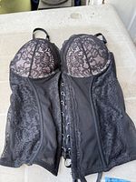 Front view of black lace bustier corset showing cups and lace panels