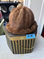 Brown mink fur hat on striped hexagonal box