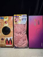 Front view of three boxed wigs showing all packaging