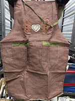 Apron removed from packaging showing design, pockets, ties