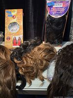 Packaged and loose wigs on table