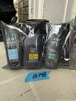 Front view of three Dove Men+Care travel bottles in sealed plastic wrap