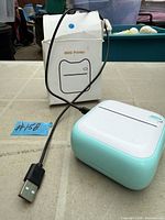 Mini printer, USB cable, and original box displayed on table