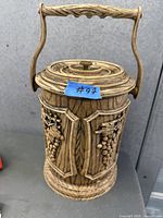 Full view of ice bucket showing lid, handle, carved panels
