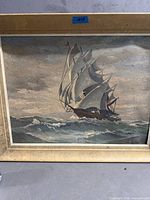 Front view of framed oil painting of sailing ship