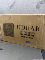 Front of sealed UDEAR wardrobe box with branding and handling icons