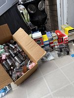 Overview of open box filled with loose vacuum tubes beside row of boxed tubes