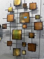 Front view of welded metal wall sculpture with square plates