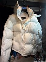 Full front view of white TNF Summit Series puffer jacket on hanger