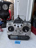 Front view of silver and black dual-stick RC transmitter showing antenna, controls and LCD