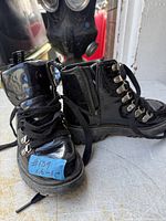Front and side view of both boots showing uppers, laces, zipper and pull tabs