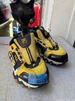 Front view of pair of yellow and black Fila kids sneakers size 3