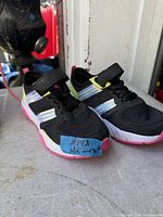 Both sneakers side view showing uppers, straps, reflective stripes