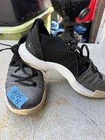 Side view of both sneakers showing uppers, laces, midsoles and size label tape