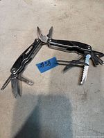 Two Powerfist multi-tools opened to show pliers, knife, screwdrivers