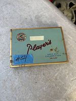 Top view of vintage Player’s cigarette tin showing logo, text and wear