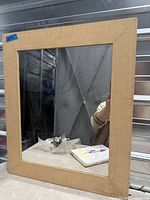 Front view of rectangular wall mirror showing wooden frame and mirror surface