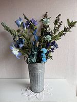 Full view of planter with faux flowers displayed upright