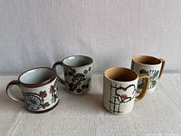 Front view of four stoneware mugs, both pairs visible