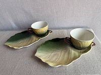 Two leaf plates each with matching cup displayed top view