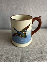 Front view showing duck motif, handle, and glazing