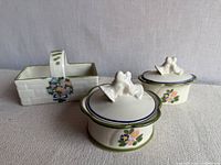 Front view of two round boxes with lids and rectangular basket