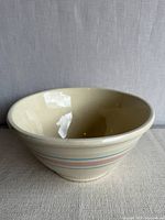 Side view of cream McCoy bowl with pastel stripes
