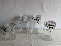 Four glass clamp-lid jars grouped