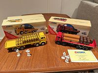 Both Corgi Classics flatbed trucks with accessory loads, figures, boxes and certificate visible