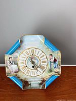 Front view showing dial and painted scene