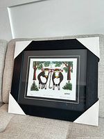 Frontal view of framed Maud Lewis print with corner protectors