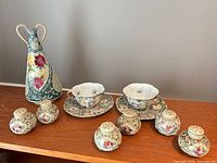 Entire lot on shelf: vase, two cup-and-saucer sets, four of the shakers visible