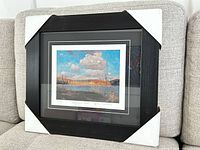 Framed print resting on sofa, full view with corner protectors